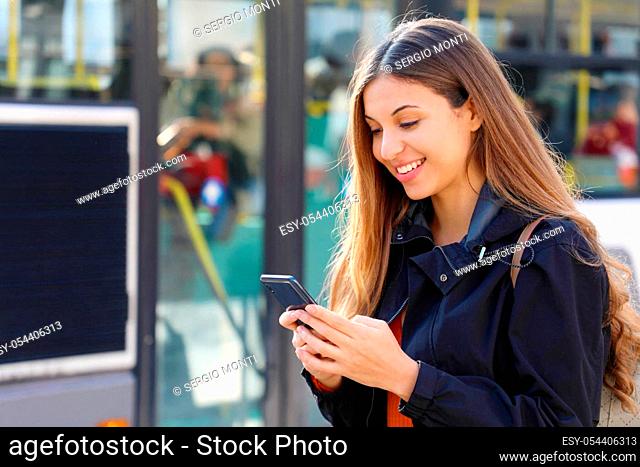 Young woman buying bus ticket online for city smart transportation. Happy beautiful student girl paying electronic ticket with smart phone app