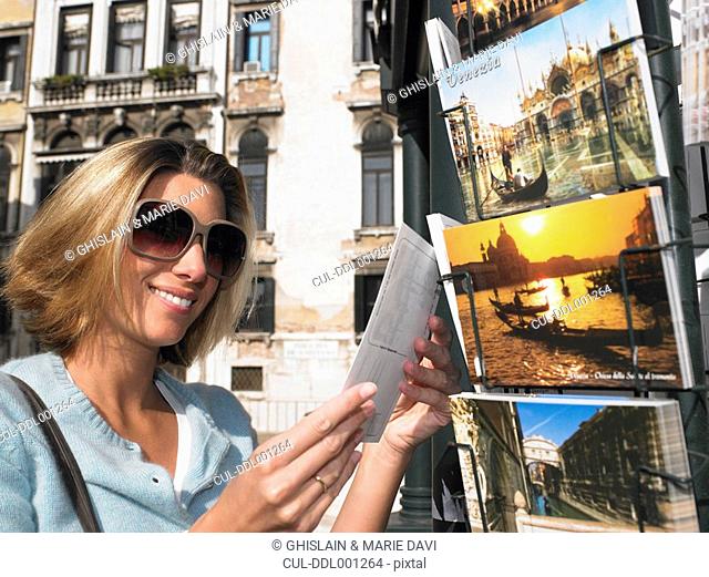 Woman choosing a postcard, smiling
