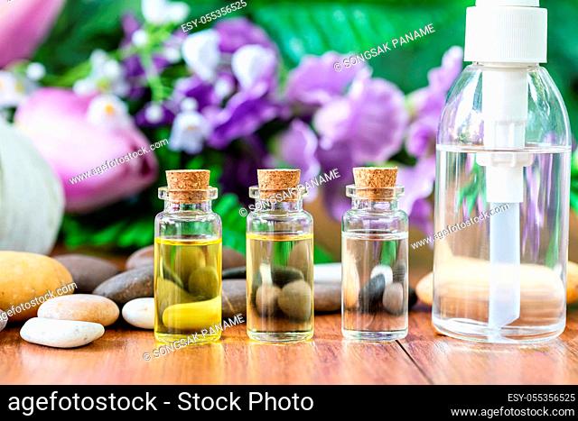 Bottle essential oil for spa massage with flower background