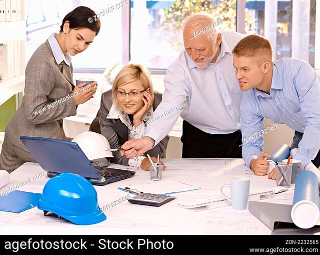 Businessteam discussing designer work on laptop computer, experienced architect pointing at screen