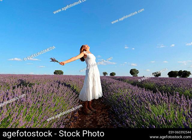 Woman outstretching holding bouquet in lavender field