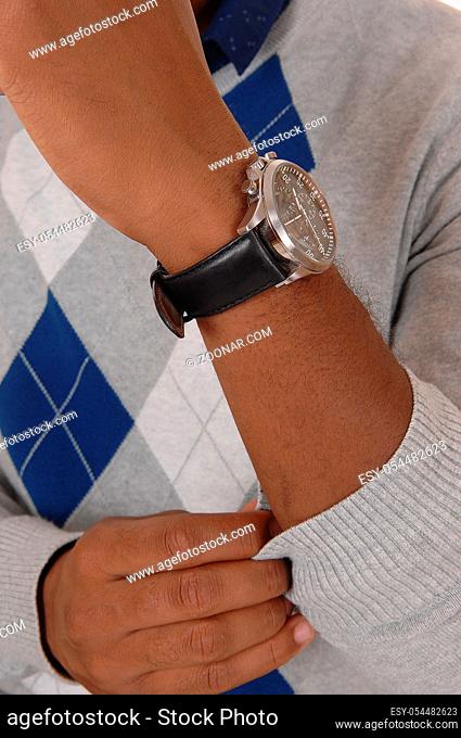 A close up image of the arm and hand of a African American man in a sweater with his wrist watch