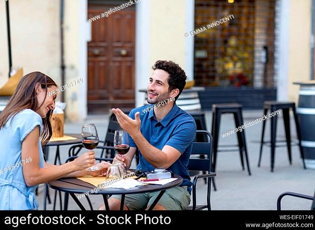 Couple talking while sitting at sidewalk cafe
