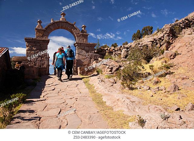 Tourists walking up the stairs to reach the town center passing through a gate, Taquile Island, Titicaca Lake, Puno Region, Peru, South America