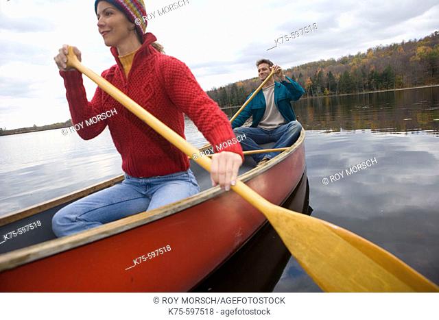 Couple canoe on lake in the fall