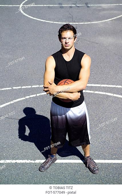 A young man standing on the free throw line at an outdoor basketball court