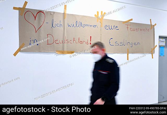 12 March 2022, Baden-Wuerttemberg, Esslingen: A poster with the inscription ""Welcome to Germany ! Eure Feuerwehr Esslingen"" hangs in an emergency shelter for...