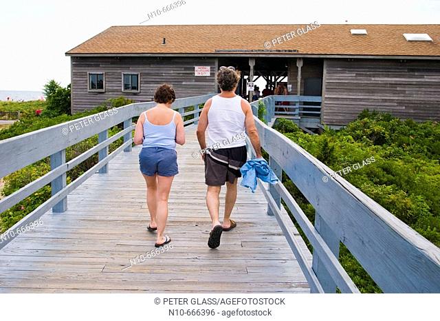 Couple walking up a wood ramp to the changing rooms at the beach