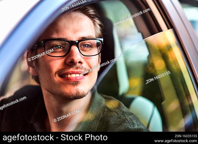 Enjoy the drive. Image of young handsome guy sitting in car