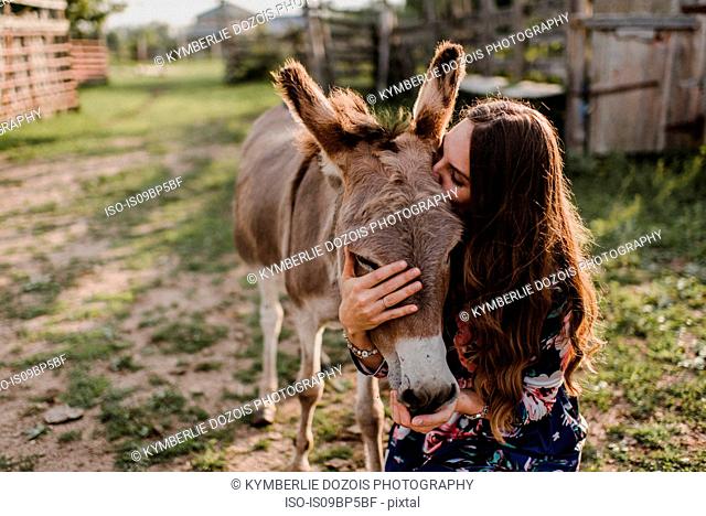 Woman kissing donkey