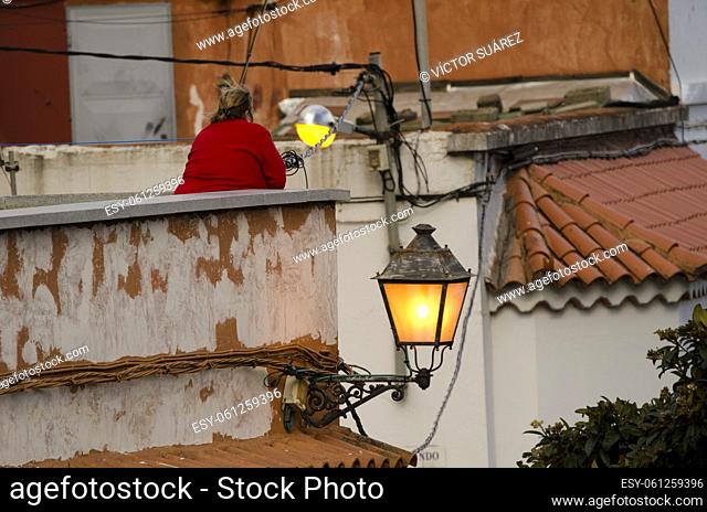 Woman on a rooftop next to a street light. San Mateo. Gran Canaria. Canary Islands. Spain