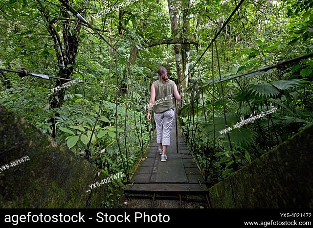 Tourist walking on a suspended bridge in the jungle of Anton Valley in Panama
