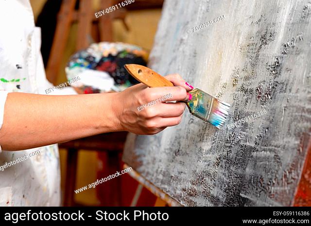 Close-up of an unrecognizable woman painter doing a brush stroke. High quality photo