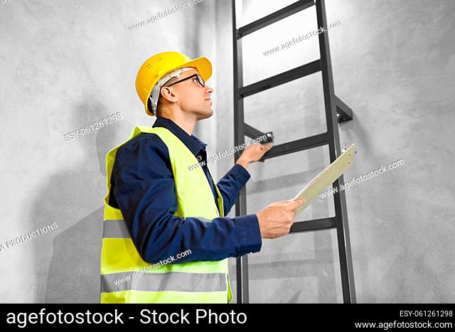 builder or worker with clipboard at ladder