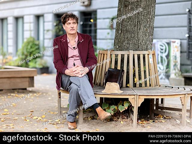 PRODUCTION - 12 September 2022, Hamburg: Frank Spilker, German musician, songwriter, novelist and singer of the band Die Sterne is sitting on a bench in his...