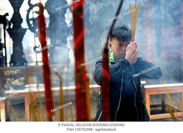 Taoist temple. Phuoc An Hoi Quan Pagoda. Buddhist Worshipper. Burning incense sticks.? Ho Chi Minh city. Vietnam. | usage worldwide