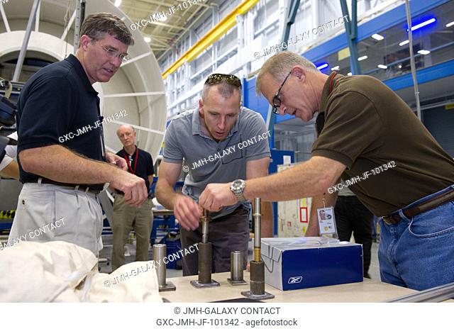In a training facility at the Johnson Space Center, from left to right, NASA astronauts Steve Bowen, Andrew Feustel and David Wolf put their heads together as...