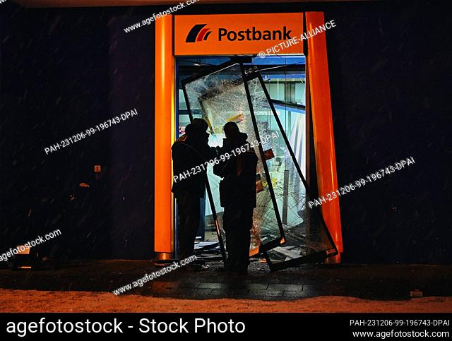 06 December 2023, Berlin: Police officers stand in the destroyed entrance area of a bank in the Märkisches Viertel. Unknown persons destroyed an ATM there