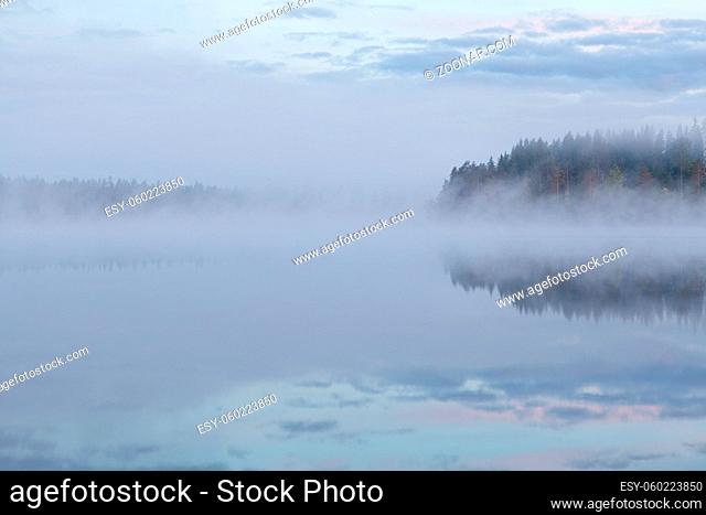 Calm foggy lake scape summer night at Finland