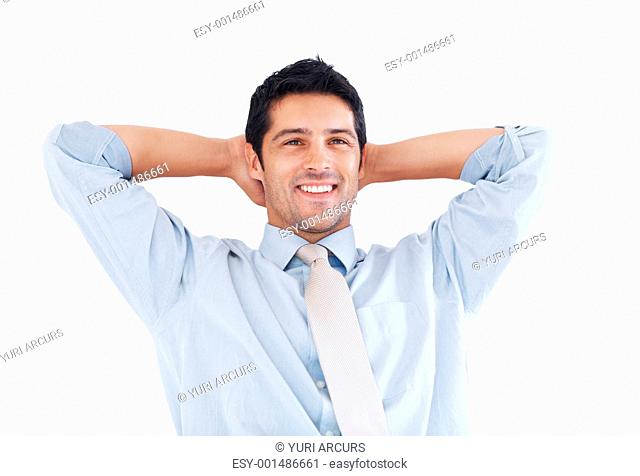 Portrait of happy young business man relaxing with hands behind head