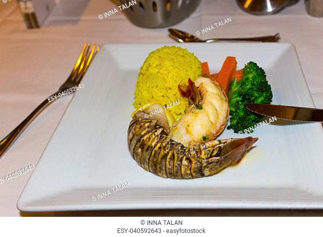 Lobster with sauce and vegetables on a white plate