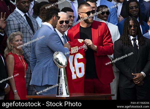 El quarterback de Kansas City Chiefs Patrick Mahomes (su traje azul claro) y el final estrecho Travis Kelce (sujeto rojo) presentan al presidente de Estados...