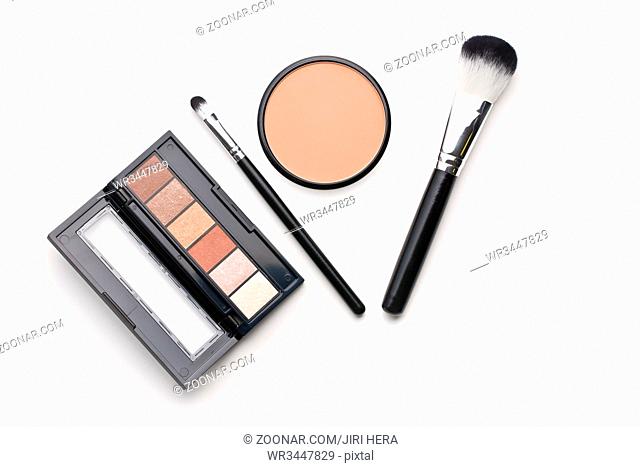The makeup products. Brush and eyeshadow powder isolated on white background