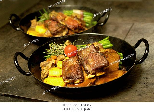 Leg of lamb and lamb ribs in a thyme sauce, and lamb ragout with bacon beans and polenta, East Tyrol, Austria