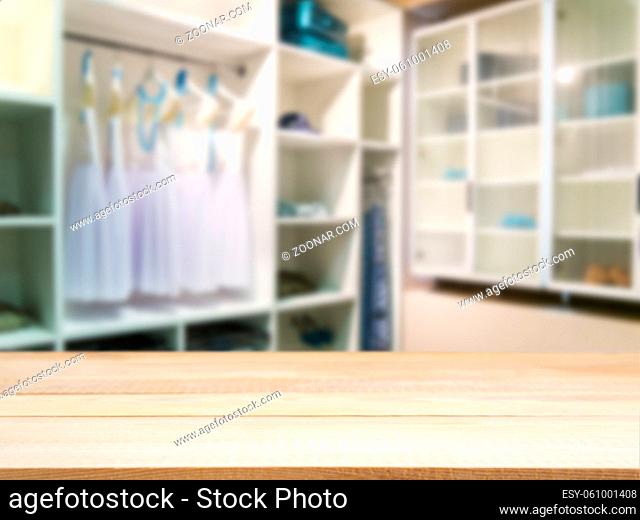 Wooden board empty table in front of blurred background. Perspective light wood over blur in closet room for background uses