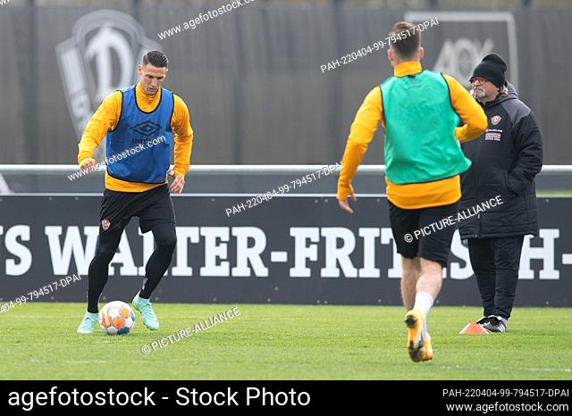 04 April 2022, Saxony, Dresden: Dynamo's Panagiotis Vlachodimos (l) plays the ball next to co-coach Heiko Scholz during a Dynamo Dresden training session at the...