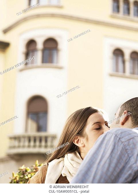 Young couple kissing in street