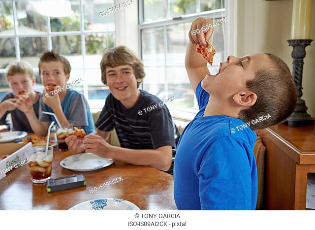 Boy swallowing pizza with mouth open