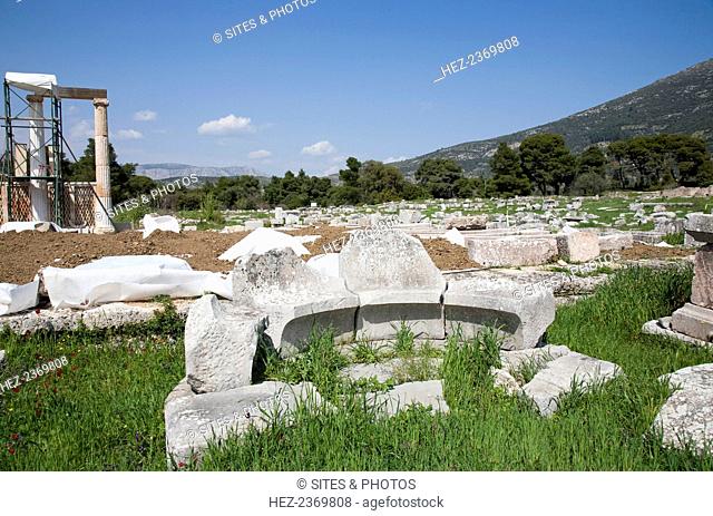An exedra in Epidauros, Greece. The original Greek sense of exedra (a seat out of doors) was applied to a room that opened onto a stoa