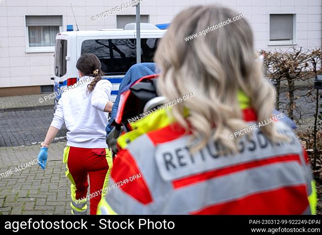 12 March 2023, Hesse, Hanau: DRK employees take a bedridden man to an ambulance in the evacuation area before an unexploded bomb is defused