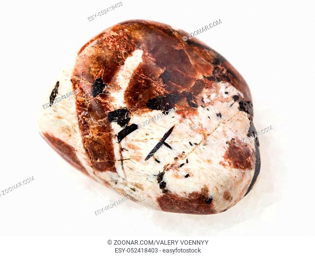 macro shooting of natural mineral rock specimen - polished Spreustein with microcline stone on white marble background from Lovozero Massif, Kola peninsula