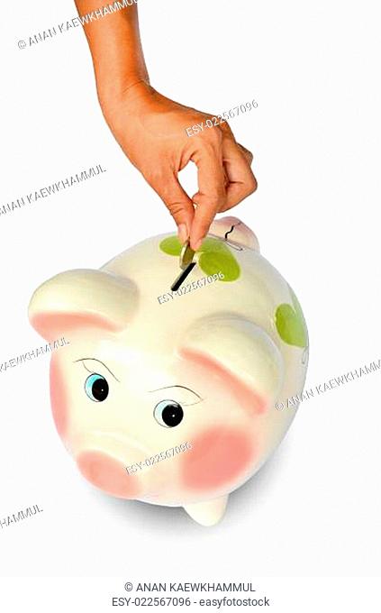 Piggy bank and hand with coin isolated