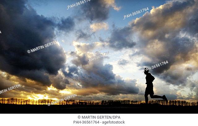 A man jogs during sunset in Duesseldorf, Germany, 30 January 2013. Photo: Martin Gerten | usage worldwide. - Duesseldorf/North Rhine-Westphalia/Germany