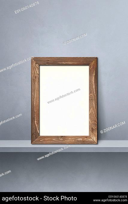 Wooden picture frame leaning on a grey shelf. 3d illustration. Blank mockup template. Vertical background