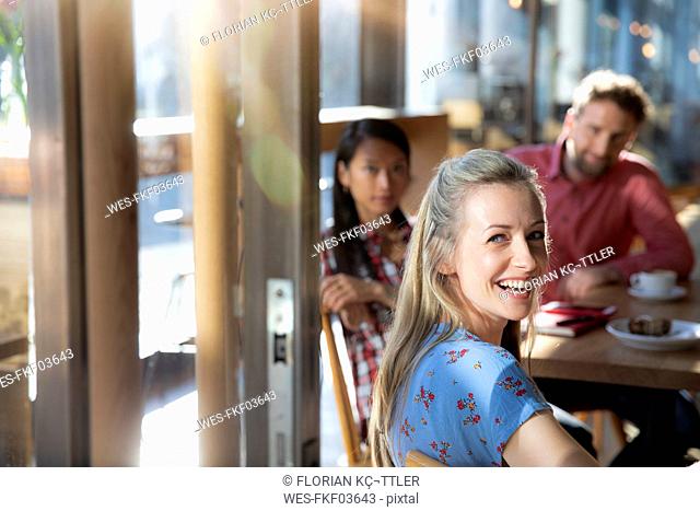 Portrait of happy woman with friends in a cafe