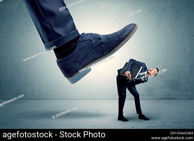Demoralised employee symbolized by small man getting trampled