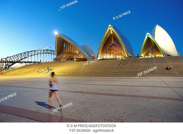 jogger and Sydney Opera House at dusk, with Harbour Bridge in the background