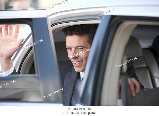 Politician waving and emerging from car