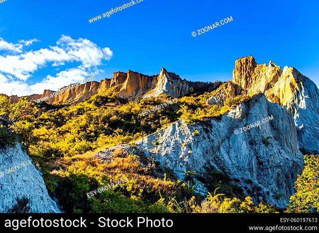 Fabulous country of New Zealand. Travel to the South Island. Warm sunny day. High white Clay cliffs with sharp peaks at sunset