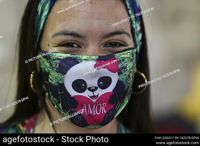 15 April 2020, Venezuela, Caracas: In the middle of the Corona pandemic, a woman is wearing a face mask with a panda and the words ""love"" written on it