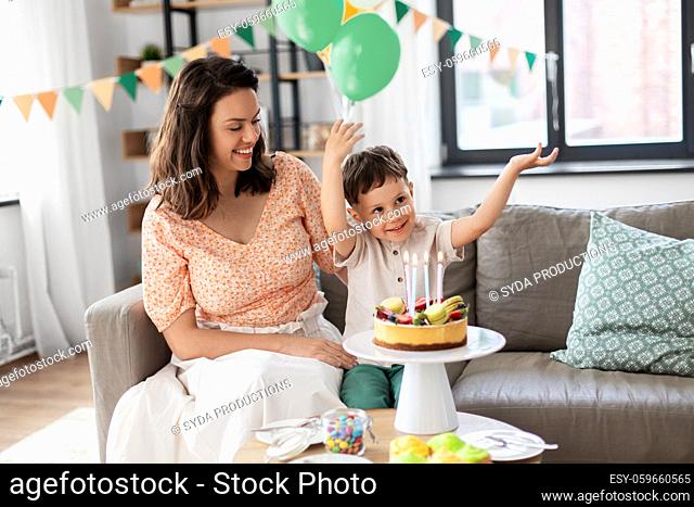 happy mother and son with birthday cake at home