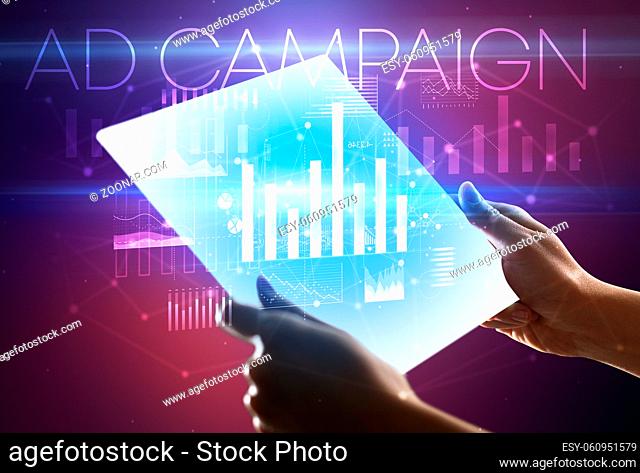 Hand holding futuristic tablet with AD CAMPAIGN inscription above, modern business concept
