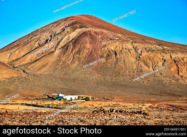 Beautiful volcanic landscape with a white house in front. Near Costa Teguise, Lanzarote, Canary Islands, Spain. Image taken from public ground