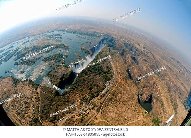 The course of the Victoria Falls, with the broad Zambezi River on the Zambian side to the left, the falls in the middle and the flow downriver in Zimbabwean...