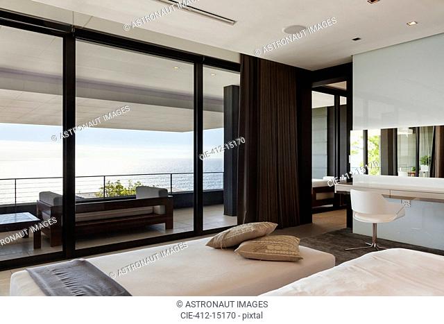 Modern bedroom and balcony overlooking ocean
