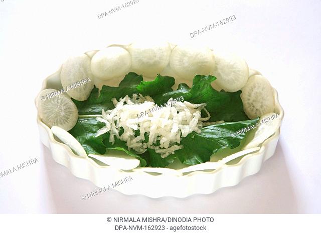 Green vegetable , round slices of muli radish raphanus sativa with green leaves on white background
